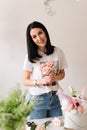 the florist collects a bouquet of flowers smiling brunette girl in a white t-shirt with flowers