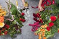 Florist creates a bouquet in a flower shop. Top view of creating a bouquet of red, orange, burgundy, yellow roses Royalty Free Stock Photo