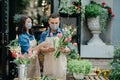 Florist creates composition of flowers. Young male and female small business owners make bouquet