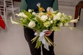 The florist creates a floral arrangement of roses, lilacs, callas, carnations, hydrangeas, brasica, alstroemeria, ornithogalum,