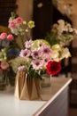 The florist creates a red beautiful bouquet of mixed flowers. Flower shop. Fresh bouquet. Master classes