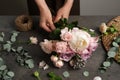 Florist creating beautiful bouquet at black table indoors, closeup Royalty Free Stock Photo