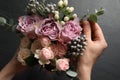 Florist creating beautiful bouquet at black table, top view Royalty Free Stock Photo