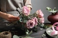 Florist creating beautiful bouquet at black wooden table indoors, closeup Royalty Free Stock Photo