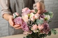 Florist creating beautiful bouquet at table indoors, closeup Royalty Free Stock Photo