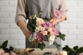 Florist creating beautiful bouquet at table indoors, closeup Royalty Free Stock Photo