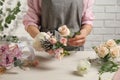 Florist creating beautiful bouquet at white table indoors, closeup Royalty Free Stock Photo