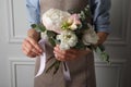 Florist creating beautiful bouquet at white wall, closeup Royalty Free Stock Photo