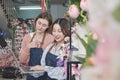 Two young beautiful female florist partners decorate lovely flora bunch for online purchase orders. Royalty Free Stock Photo