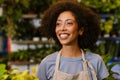 Florist girl smiling while working with potted plants in flower shop Royalty Free Stock Photo