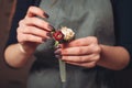 Florist hands creating flower decoration closeup.