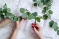 Florist hands make eucalyptus bouquet