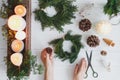 Florist hands making rustic christmas wreath with fir branches,flat lay