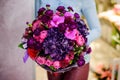 Florist holding a gorgeous purple bouquet of flowers