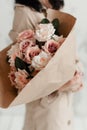 The florist holds in her hands a beautiful colorful bouquet of decorative flowers made of pink roses Royalty Free Stock Photo