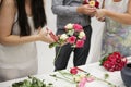 florist makes the bride`s bouquet with their own hands. the girl creates a beautiful bouquet. in the background, a man helps a wo