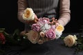 Florist making beautiful bouquet at black table, closeup Royalty Free Stock Photo