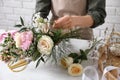 Florist making beautiful bouquet at white table, closeup Royalty Free Stock Photo