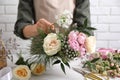 Florist making beautiful bouquet at white table, closeup Royalty Free Stock Photo