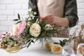 Florist making beautiful bouquet at white table, closeup Royalty Free Stock Photo