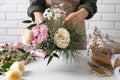 Florist making beautiful bouquet at white table, closeup Royalty Free Stock Photo