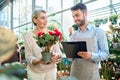 florist seller and a buyer in a flower shop .