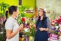 Florist serves female customer in buying flowers at store. Royalty Free Stock Photo