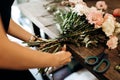 Florist ties a ribbon on the stems of flowers in flower shop Royalty Free Stock Photo