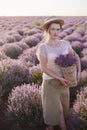 Florist with wicker basket with lavender in her hands looks for the best fresh flowers in the fields Royalty Free Stock Photo