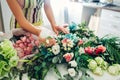 Florist woman creating flower composition at home. Worker composing wedding bouquet. Small business