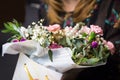 Florist woman holding a beautiful blossoming flowers bouquet in pink and green colors of roses, peony, myrtle, pistachio leaves.