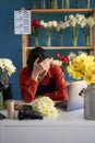 Florist woman stressed while working on laptop, Tired businesswoman with headache at her flowers shop, feeling sick at Royalty Free Stock Photo