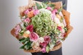 Florist at work. Make hydrangea rich bouquet. Vintage floristic background, colorful roses, antique scissors and a rope