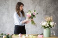 Florist at work: pretty young woman making fashion modern bouquet of different flowers Royalty Free Stock Photo