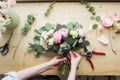 Florist at work: pretty young woman making fashion modern bouquet of different flowers Royalty Free Stock Photo