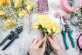 Florist at work. Woman making bouquet of yellow carnations