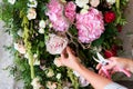 Florist at work. Woman making spring floral decorations the wedding table , the bride and groom.