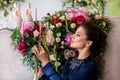 Florist at work. Woman making spring floral decorations the wedding table , the bride and groom. Flowers, candles, a bottle of ch Royalty Free Stock Photo