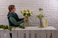 Florist workplace on the light background. The florist creates a floral arrangement of roses, lilacs, callas, carnations, Royalty Free Stock Photo