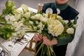 Florist workplace on the light background. The florist creates a floral arrangement of roses, lilacs, callas, carnations, Royalty Free Stock Photo