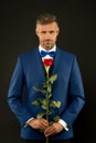 Floristics for ceremonies. Rich groom at wedding. handsome man in tuxedo with bowtie. red rose symbol of passion and