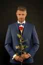 Floristics for ceremonies. Rich groom at wedding. handsome man in tuxedo with bowtie. red rose symbol of passion and