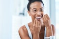 Floss for a better clean. an young woman flossing her teeth in the bathroom at home. Royalty Free Stock Photo