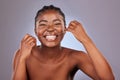 Flossing to reach all those in between spots. a young woman flossing her teeth while standing against a studio Royalty Free Stock Photo