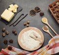 Flour in bowl, butter and set of spices for preparing dough on gray surface