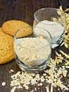 Flour and bran oat in glass with cookies on board