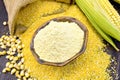 Flour corn in bowl with grits and grains on dark board