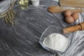 Flour, egg, olive oil, milk, wheat ears, kitchen tool on gray table background Royalty Free Stock Photo