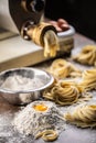 Flour, eggs and a pasta maker producing fresh Italian fettuccine