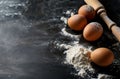 Flour, Eggs, and Rolling Pin on Black Surface